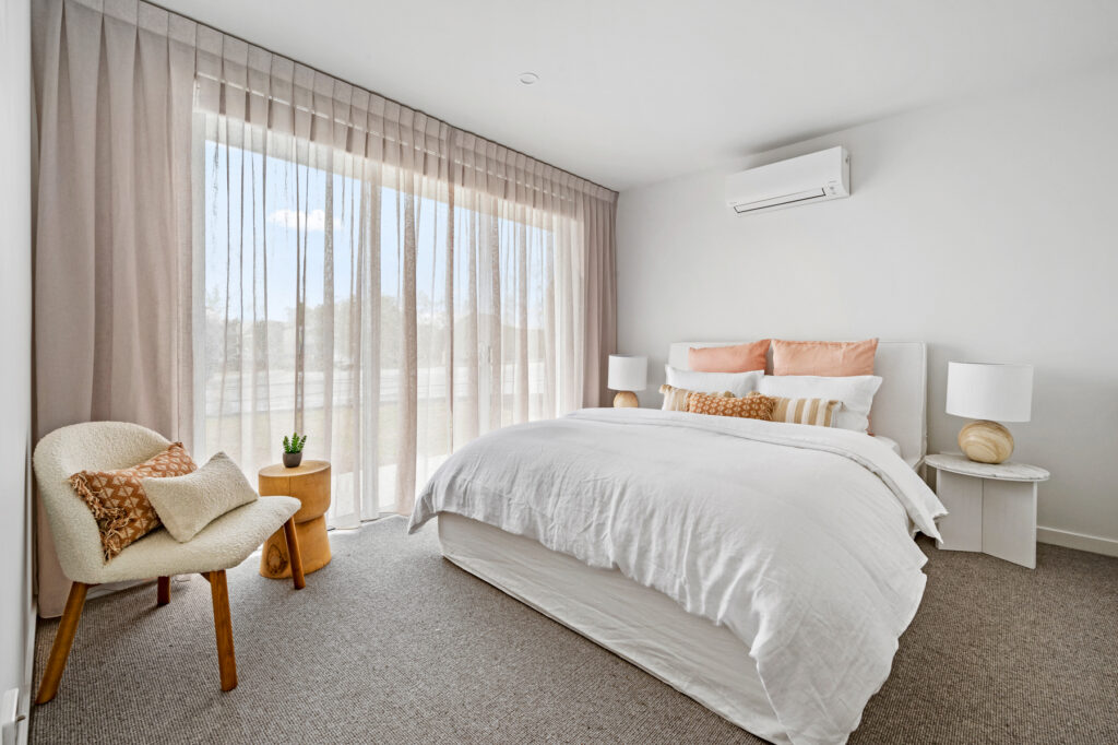 View of bedroom with a queen bed, side tables and a chair