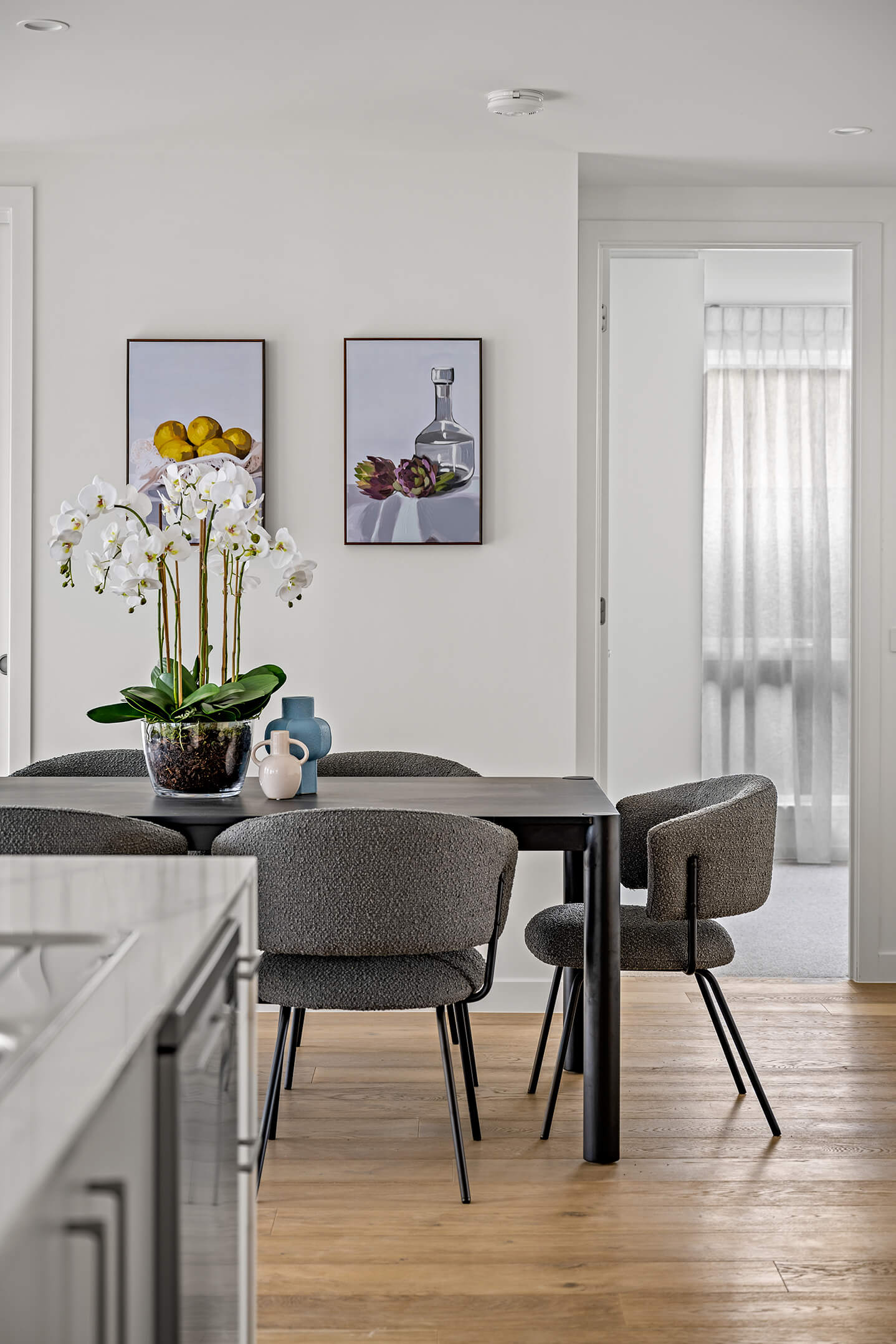 dining chairs in a dining area seen from the kitchen with part of the island bench on the left