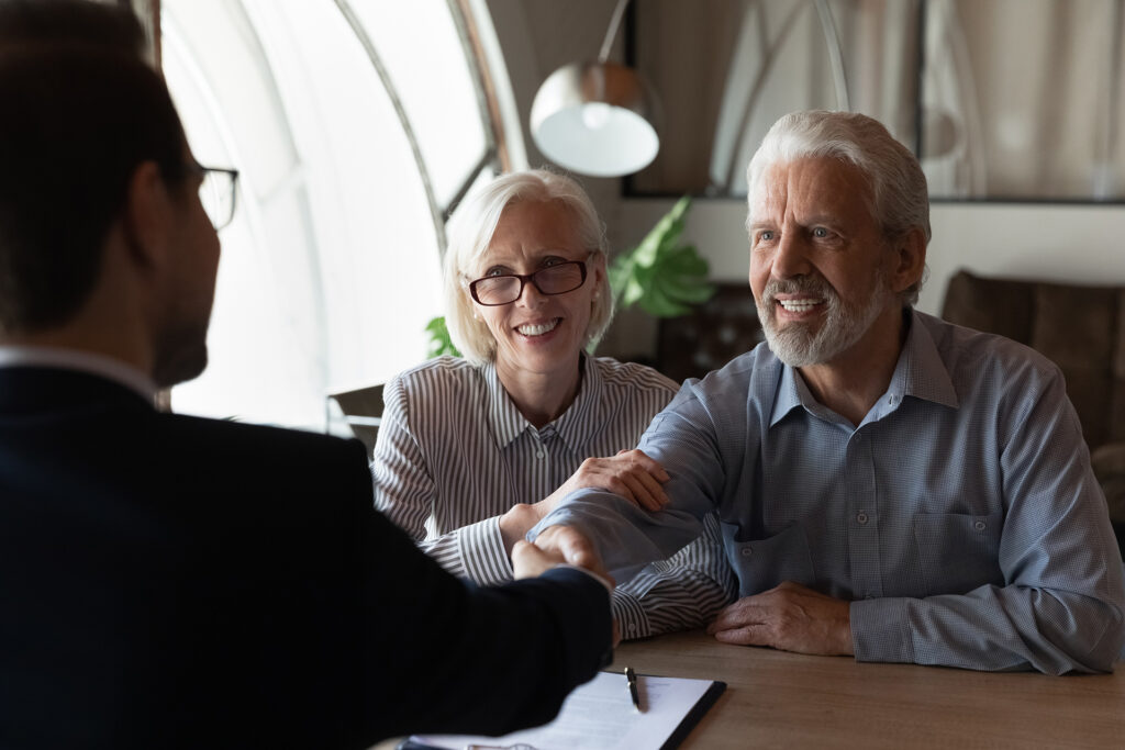 Older couple shaking hands with financial advisor